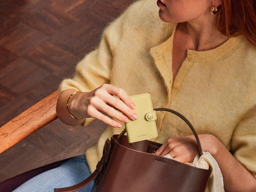 Ženska ruka drži Secrid Butter Yellow novčanik – elegantan i praktičan
